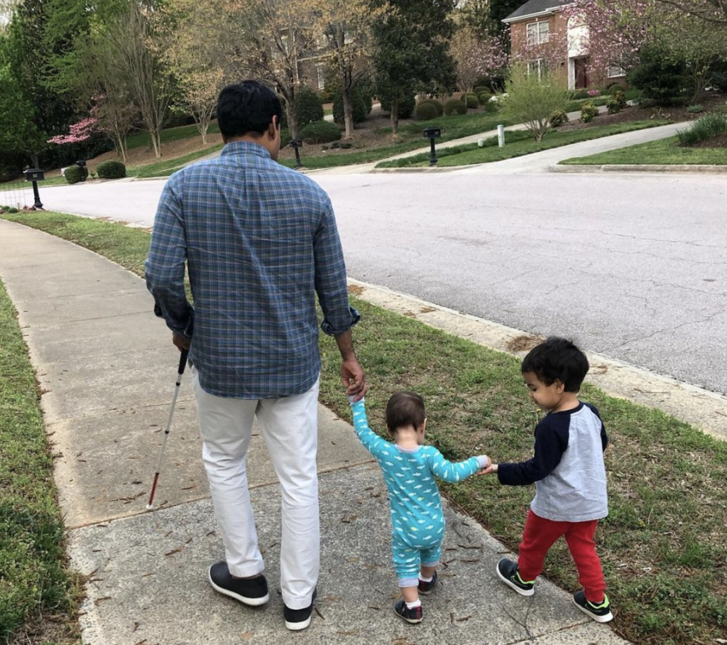John Samuel walking with his two sons