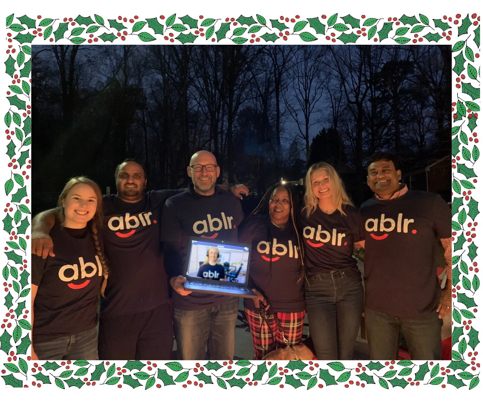 Ablr team, standing and smiling outside at night, all of them are wearing the Ablr t-shirt.