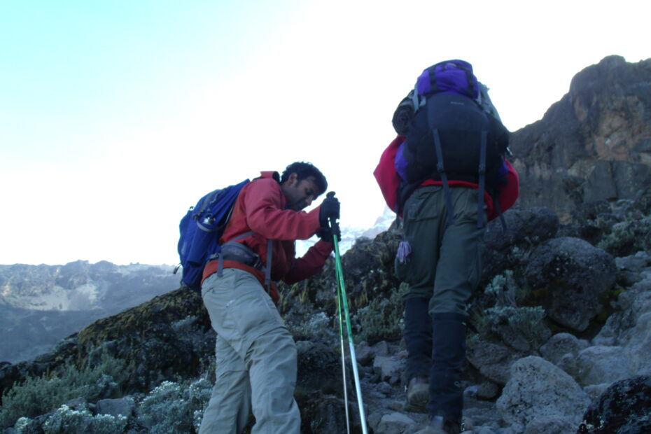 John and his guide, Stephen, climbing up the rocky slopes of Mount Kilimanjaro.