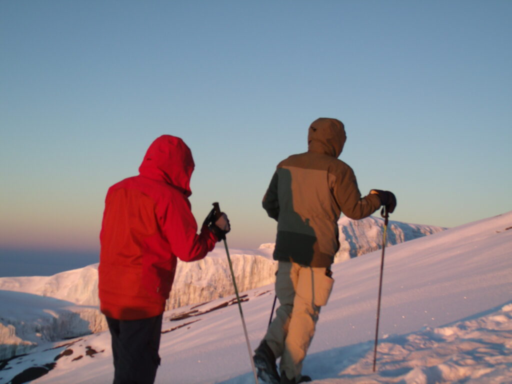 John and his guide, Stephen, climbing up the snowy slopes of Mount Kilimanjaro.